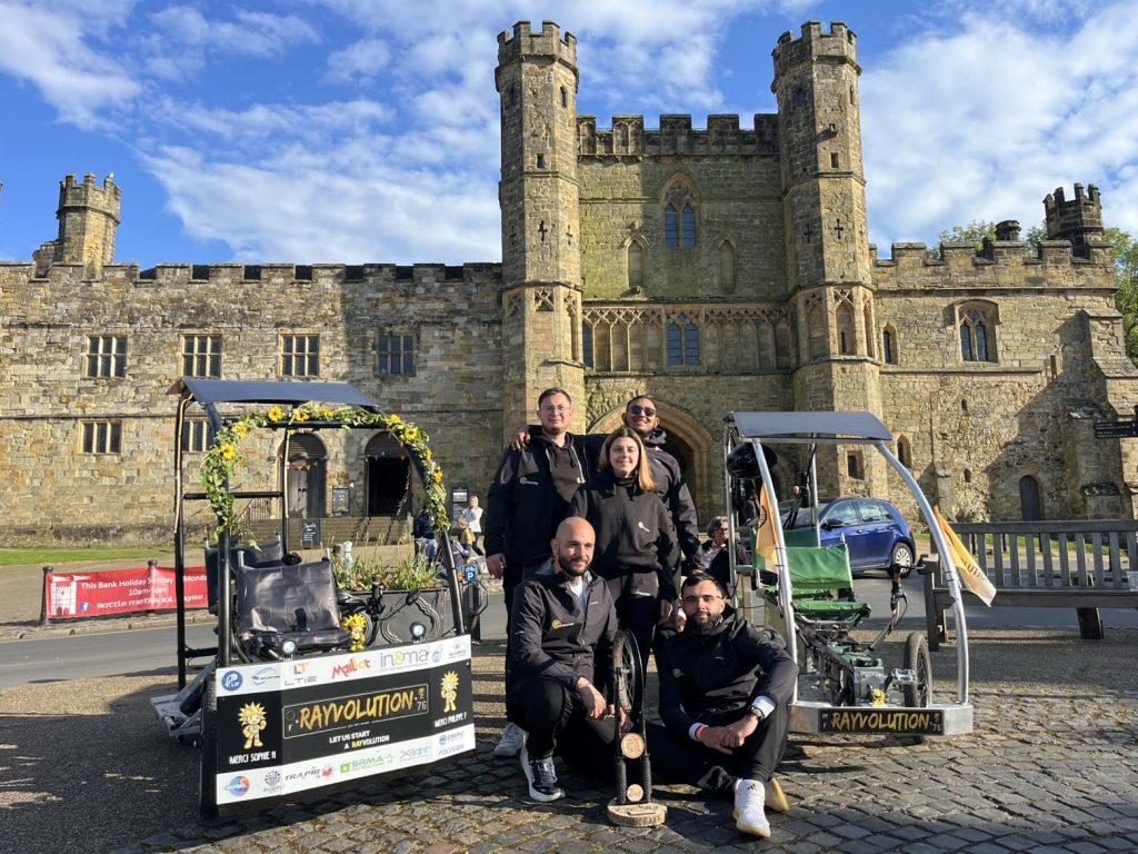 L’équipe Rayvolution et deux Vhélios adaptés devant un château