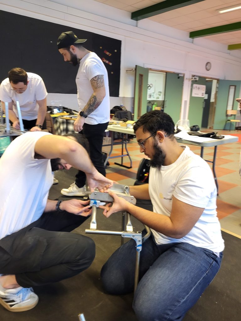 Participants assemblant une pièce mécanique pendant un atelier Vhélio