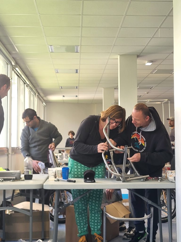 Deux participants travaillent ensemble sur le châssis d’un Vhélio